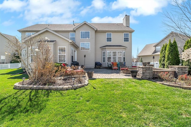 rear view of house featuring a patio area, a chimney, and an outdoor living space with a fire pit