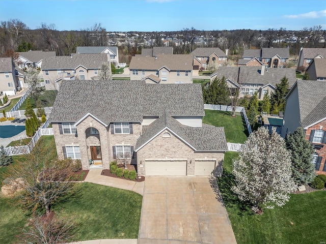view of front of home featuring a residential view, concrete driveway, a garage, and a shingled roof