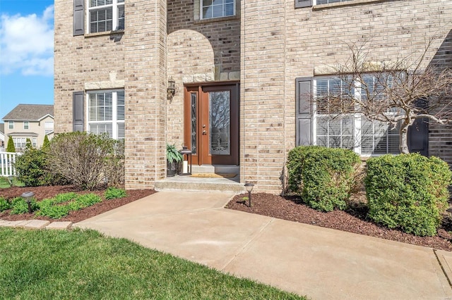 entrance to property featuring brick siding