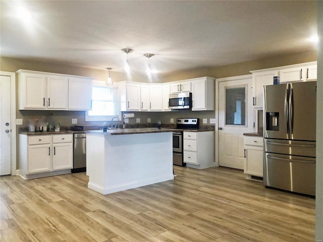 kitchen with stainless steel appliances, white cabinetry, and light wood finished floors
