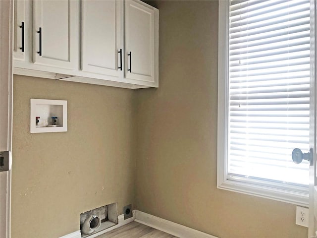 clothes washing area with hookup for an electric dryer, washer hookup, baseboards, cabinet space, and wood finished floors