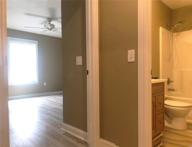 full bath with wood finished floors, toilet,  shower combination, and vanity