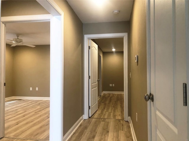 hallway with light wood finished floors and baseboards