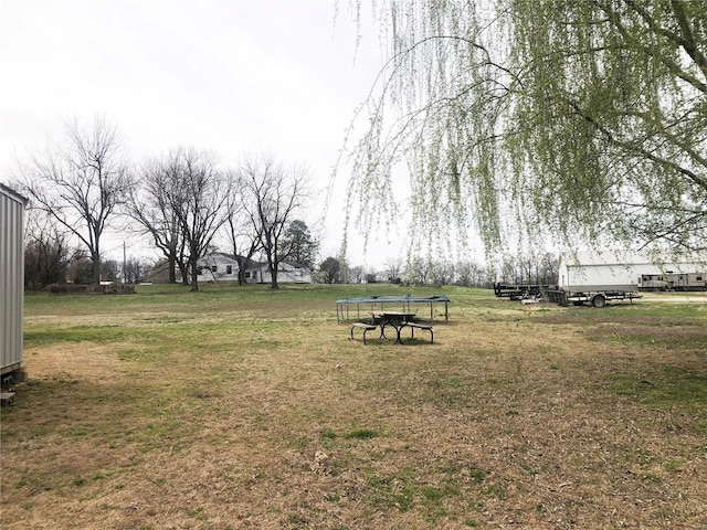 view of home's community with a trampoline and a lawn