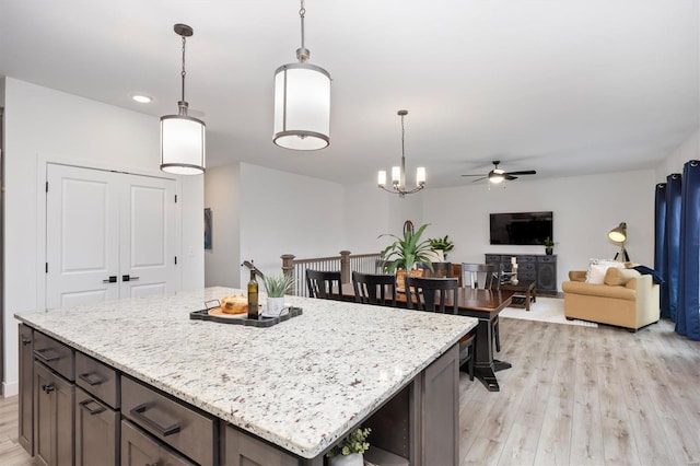 7121 Lost Oak Dr, Edwardsville, IL 62025 - kitchen featuring a ceiling fan, light wood finished floors, hanging light fixtures, light stone countertops, and recessed lighting