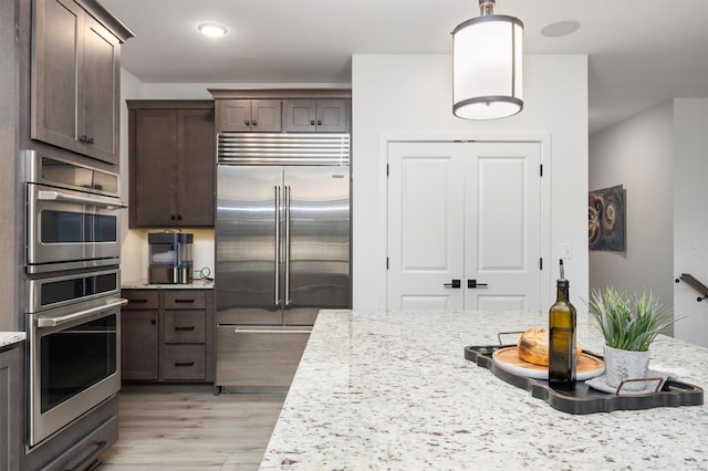 7121 Lost Oak Dr, Edwardsville, IL 62025 - kitchen with appliances with stainless steel finishes, dark brown cabinets, light wood-type flooring, hanging light fixtures, and recessed lighting