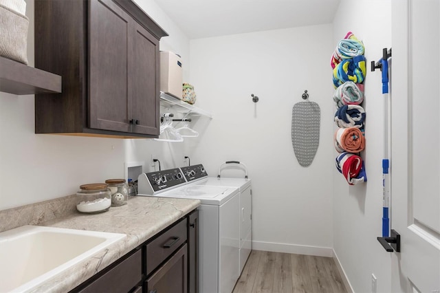7121 Lost Oak Dr, Edwardsville, IL 62025 - clothes washing area with independent washer and dryer, cabinet space, light wood-style floors, and baseboards
