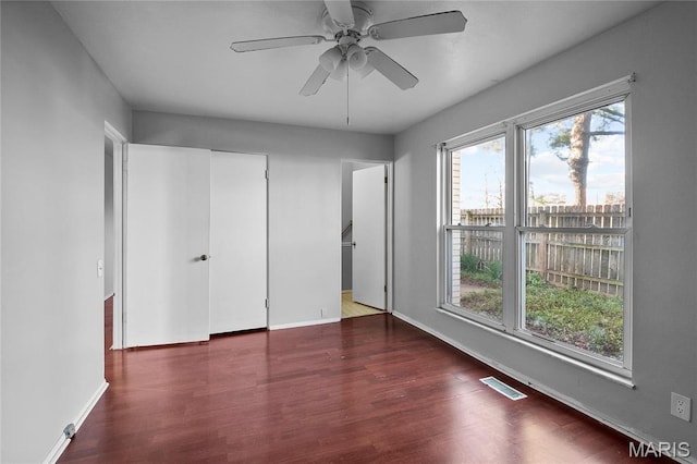 10469 Briarbend Dr Unit 4, Saint Louis, MO 63146 - unfurnished bedroom featuring multiple windows, wood finished floors, baseboards, and a ceiling fan