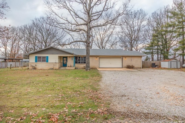 view of front facade with a storage shed, gravel driveway, an attached garage, and an outbuilding