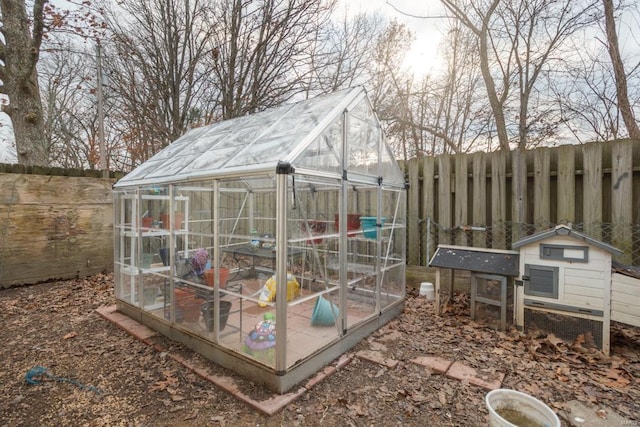 view of greenhouse featuring fence