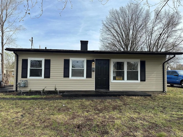 view of front of property featuring a front lawn and a chimney