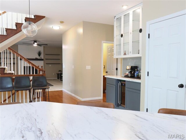 6804 Laurel Springs Ct, Fairview Heights, IL 62208 - indoor dry bar with stairs, wood finished floors, ceiling fan, baseboards, and decorative light fixtures