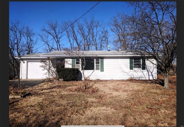 single story home with an attached garage and asphalt driveway