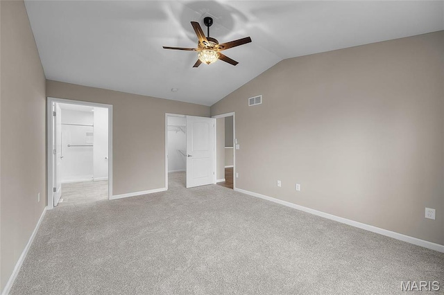 1542 Hickory Lndg, De Soto, MO 63020 - unfurnished bedroom featuring a walk in closet, lofted ceiling, baseboards, carpet, and a closet