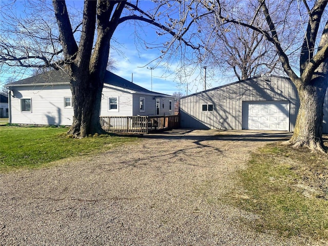 106 S 3rd, Novelty, MO 63460 - view of front of property featuring a garage, an outbuilding, a wooden deck, a front yard, and driveway
