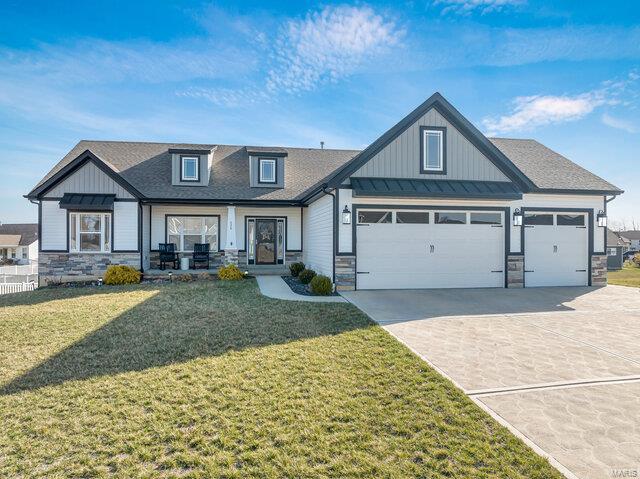 620 Lubbuck Ct, Moscow Mills, MO 63362 - view of front of house with stone siding, a garage, board and batten siding, and a front lawn