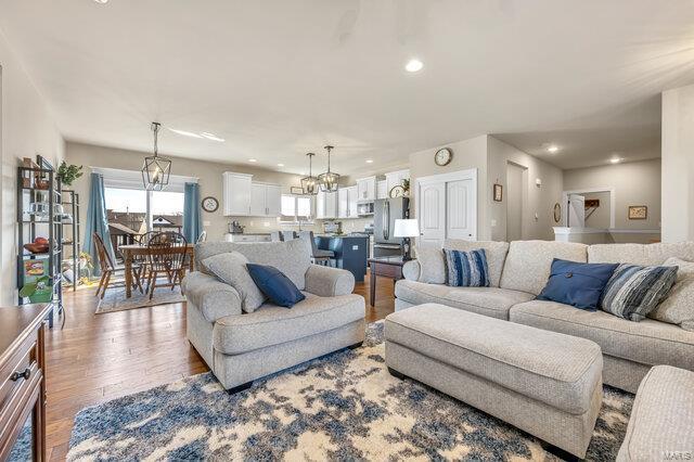620 Lubbuck Ct, Moscow Mills, MO 63362 - living area featuring wood finished floors, a chandelier, and recessed lighting