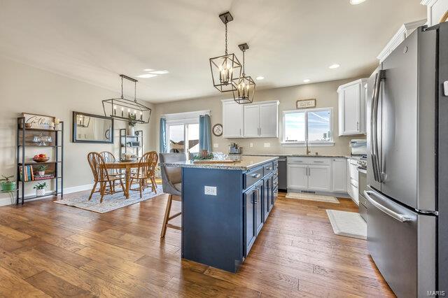 620 Lubbuck Ct, Moscow Mills, MO 63362 - kitchen featuring freestanding refrigerator, plenty of natural light, white cabinetry, a kitchen bar, and recessed lighting