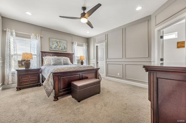 620 Lubbuck Ct, Moscow Mills, MO 63362 - bedroom featuring a decorative wall, multiple windows, light colored carpet, a ceiling fan, and recessed lighting