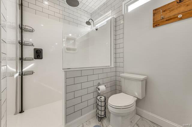 620 Lubbuck Ct, Moscow Mills, MO 63362 - bathroom with a walk in shower, marble look tile flooring, toilet, and baseboards