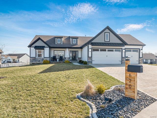 620 Lubbuck Ct, Moscow Mills, MO 63362 - view of front of home with stone siding, an attached garage, board and batten siding, and a front lawn