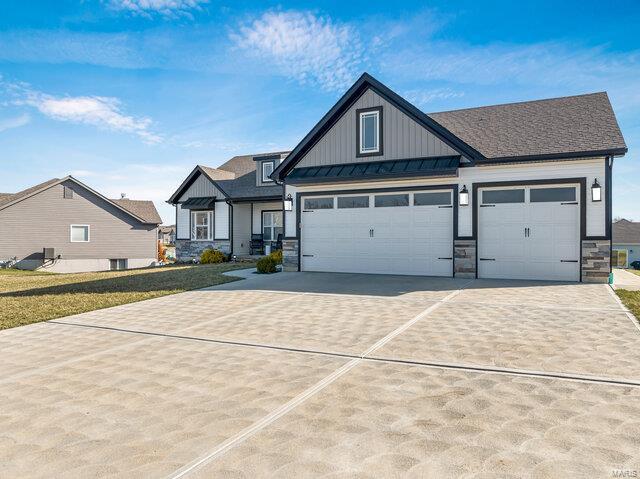 620 Lubbuck Ct, Moscow Mills, MO 63362 - view of front facade with board and batten siding, driveway, stone siding, and an attached garage