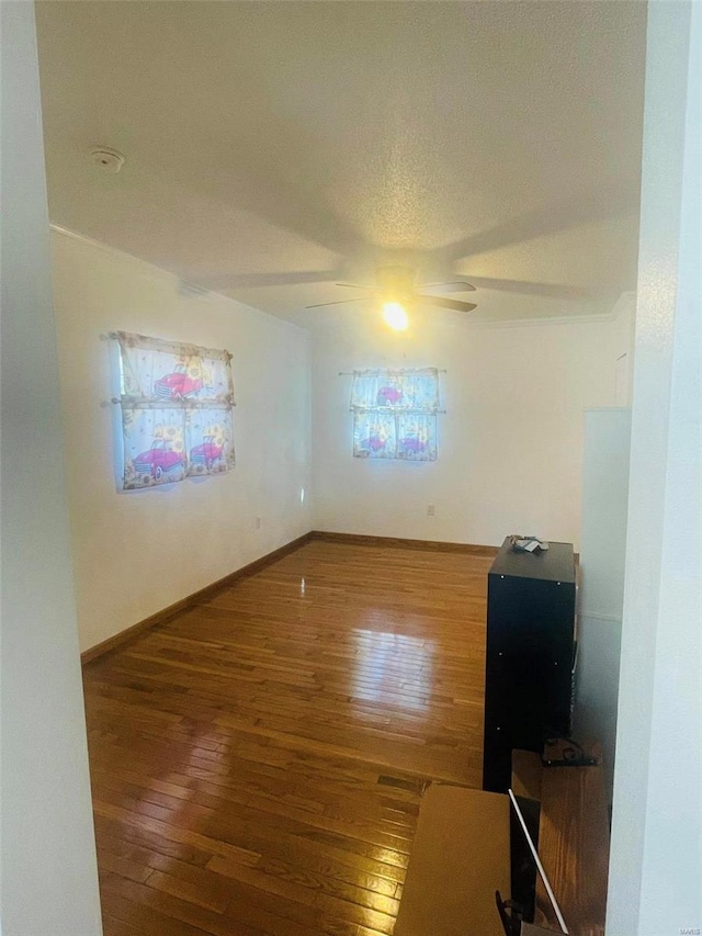 unfurnished room featuring hardwood / wood-style flooring, a ceiling fan, baseboards, and a smoke detector
