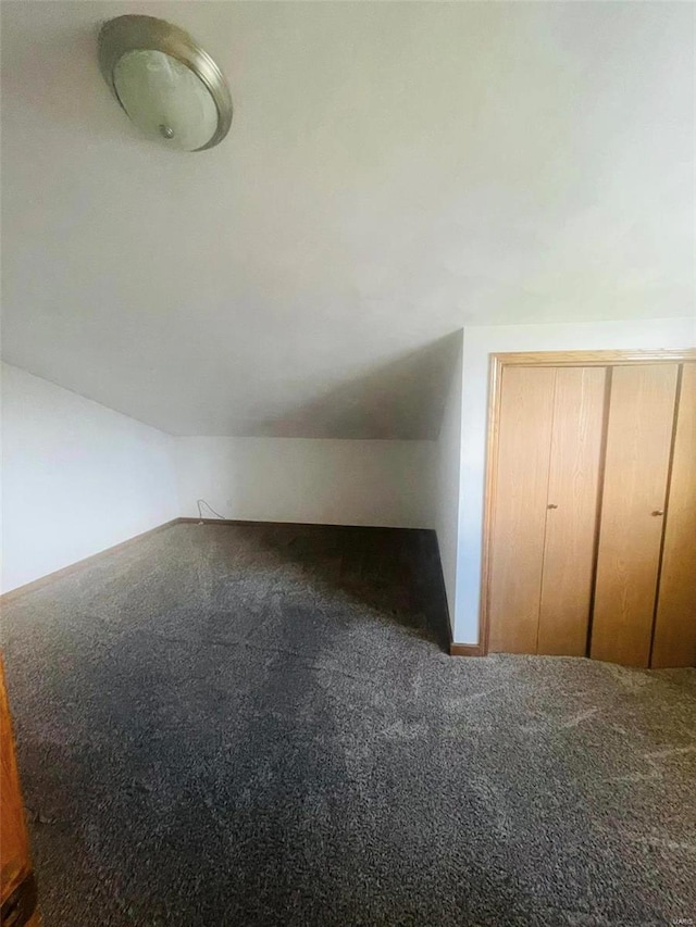 additional living space featuring carpet flooring, vaulted ceiling, and baseboards