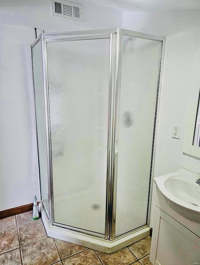 full bath featuring tile patterned flooring, a shower stall, and vanity
