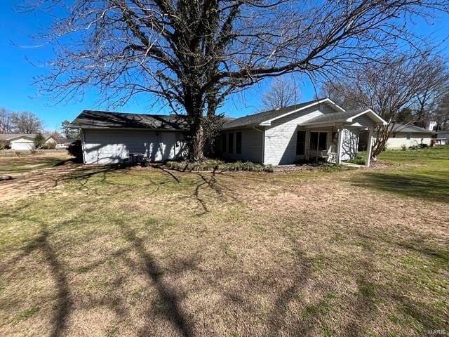 view of side of home featuring a lawn and a porch