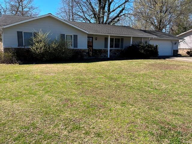 single story home featuring a garage, a front yard, and driveway