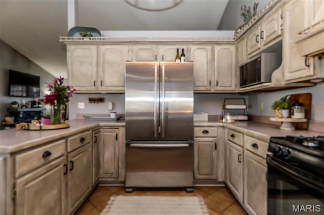 110 Southwood Trce, Collinsville, IL 62234 - kitchen with stainless steel fridge, a peninsula, light tile patterned floors, light countertops, and vaulted ceiling