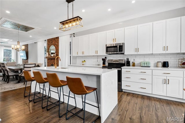 4716 Olive St, Saint Louis, MO 63108 - kitchen featuring appliances with stainless steel finishes, a sink, a chandelier, backsplash, and light countertops