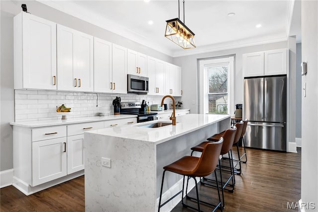 4716 Olive St, Saint Louis, MO 63108 - kitchen featuring appliances with stainless steel finishes, a sink, ornamental molding, backsplash, and white cabinets