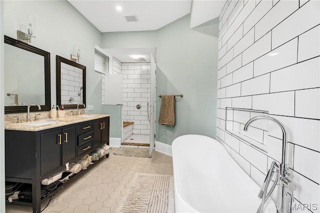 4716 Olive St, Saint Louis, MO 63108 - full bath with a stall shower, a freestanding tub, double vanity, tile patterned floors, and baseboards