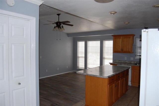 5711 Cedar Valley Dr, Poplar Bluff, MO 63901 - kitchen with freestanding refrigerator, ceiling fan, dishwashing machine, brown cabinets, and dark wood finished floors