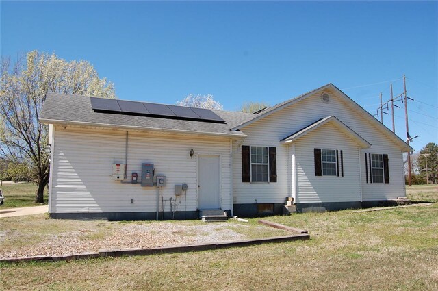 5711 Cedar Valley Dr, Poplar Bluff, MO 63901 - rear view of house featuring solar panels, a lawn, and roof with shingles