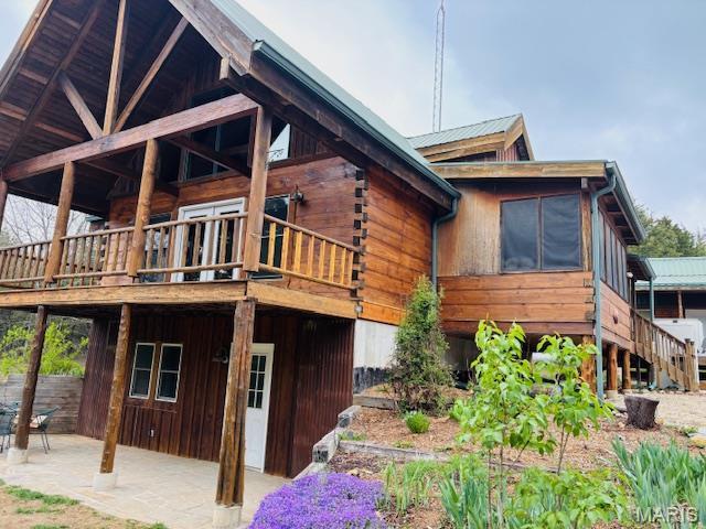 19125 County Road 1220, St James, MO 65559 - view of side of home featuring a patio, a wooden deck, and log siding