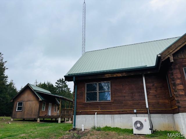 19125 County Road 1220, St James, MO 65559 - view of side of home featuring ac unit, metal roof, and a yard