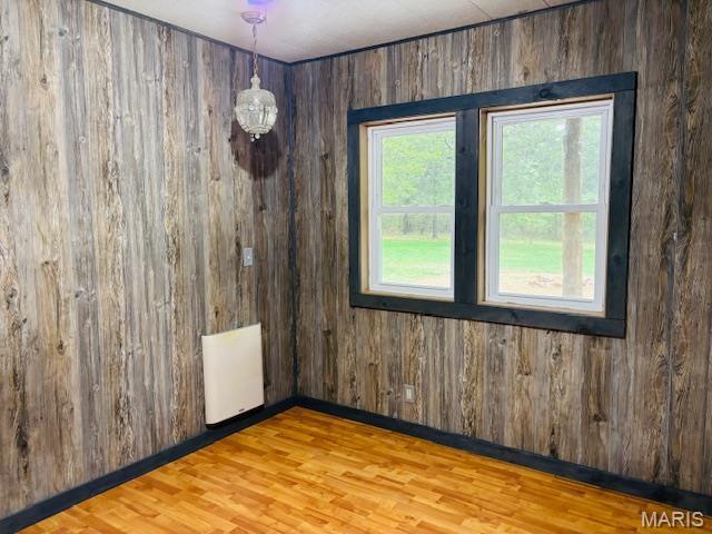 19125 County Road 1220, St James, MO 65559 - empty room with wood walls, wood finished floors, and radiator heating unit