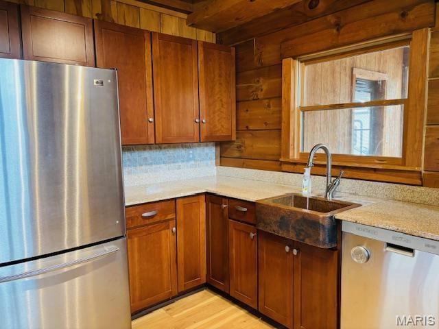19125 County Road 1220, St James, MO 65559 - kitchen with stainless steel appliances, a sink, light wood-type flooring, brown cabinets, and light stone countertops