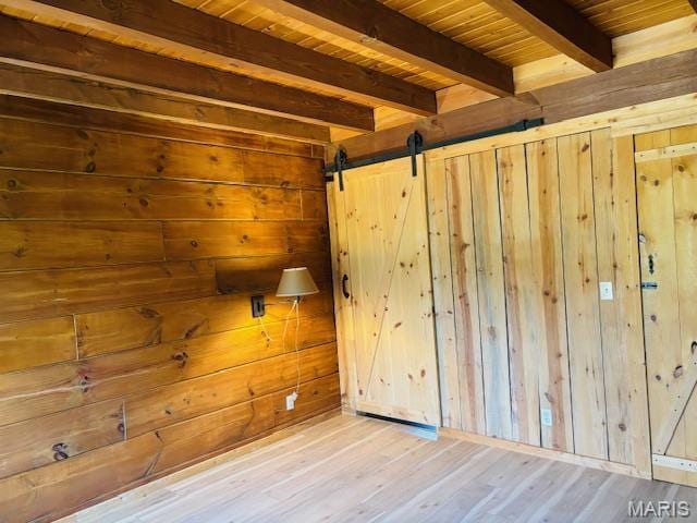 19125 County Road 1220, St James, MO 65559 - unfurnished room with wooden ceiling, wooden walls, beamed ceiling, wood finished floors, and a barn door