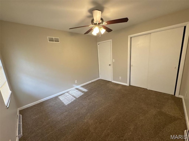 2355 Redman Rd, Saint Louis, MO 63136 - unfurnished bedroom with dark carpet, baseboards, a ceiling fan, and a closet