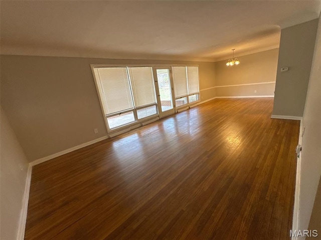 2355 Redman Rd, Saint Louis, MO 63136 - empty room with a chandelier, baseboards, and dark wood-style floors