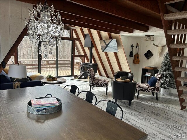 628 W St Gallen Dr, Innsbrook, MO 63390 - dining room featuring a wood stove, beam ceiling, wood finished floors, and stairway