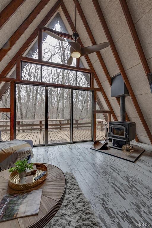 628 W St Gallen Dr, Innsbrook, MO 63390 - living room with a wood stove, high vaulted ceiling, a ceiling fan, hardwood / wood-style floors, and floor to ceiling windows
