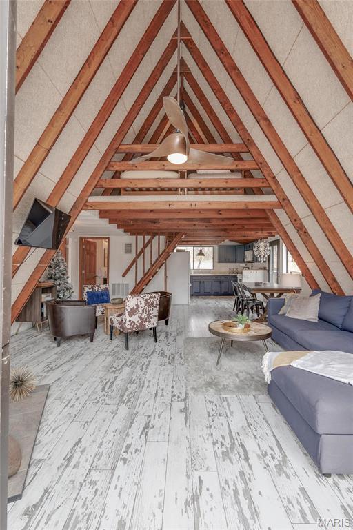 628 W St Gallen Dr, Innsbrook, MO 63390 - living area featuring wood-type flooring, beam ceiling, stairs, and high vaulted ceiling
