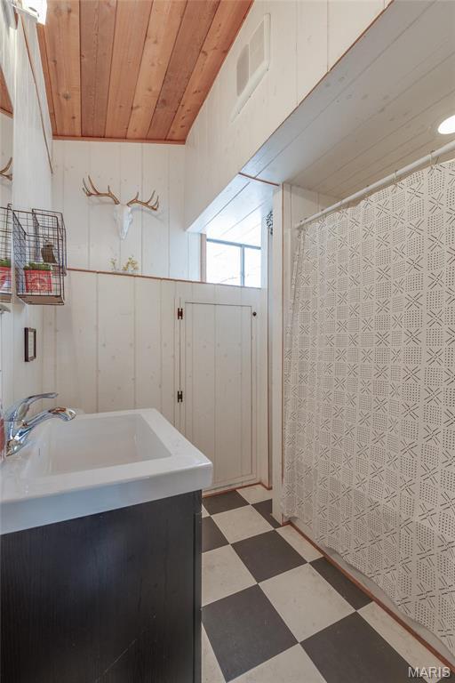 628 W St Gallen Dr, Innsbrook, MO 63390 - full bathroom with tile patterned floors, wood ceiling, vanity, and a shower with curtain