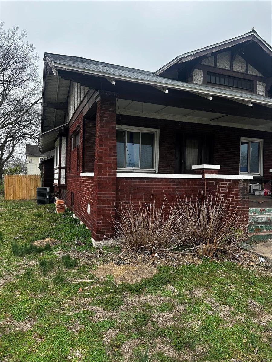 830 N Wood River Ave, Wood River, IL 62095 - view of home's exterior featuring brick siding, fence, and central AC