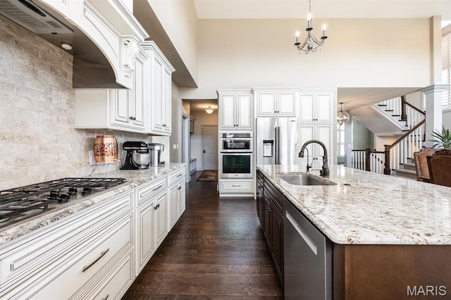 7032 Koufax Ct, Edwardsville, IL 62025 - kitchen featuring a chandelier, stainless steel appliances, a sink, dark wood-type flooring, and light stone counters